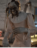 Evil clown animatronic holding doll with violent motion in haunted carnival scene